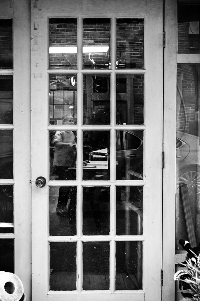 Man at a work bench through a window