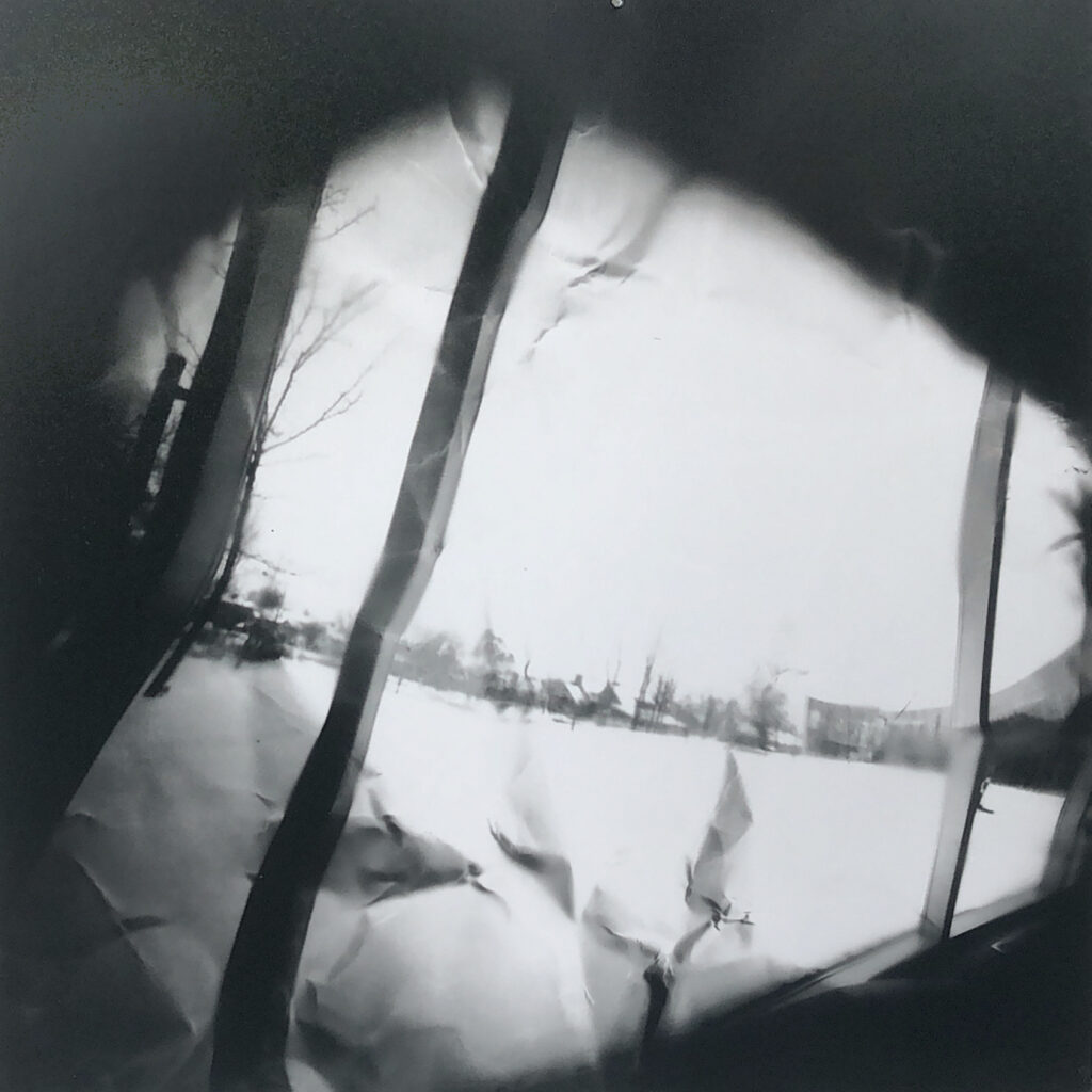 a pinhole image of the veiw out of the windows of KTSA looking onto the amphitheater printed onto a crumpled piece of paper